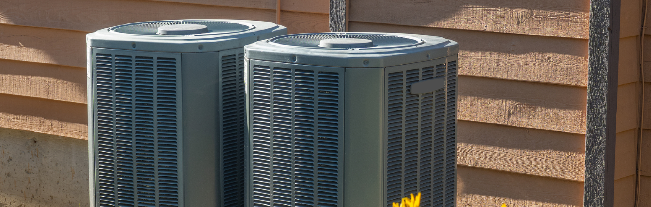 Photo of two air conditioning handlers outside a home or business