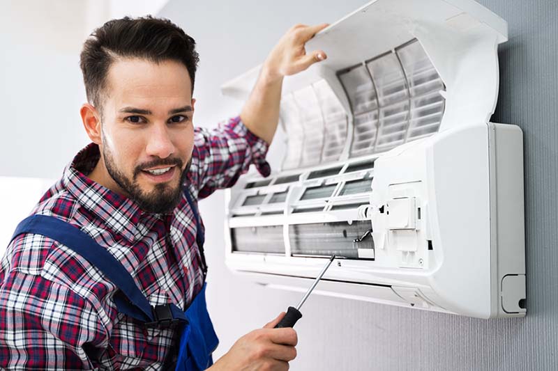 air conditioner service man repairing mini split