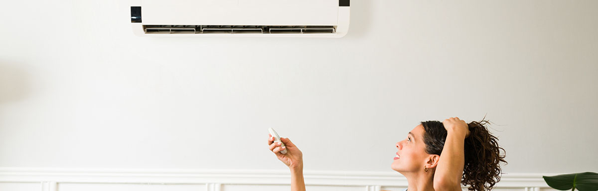 Hot young woman feeling sweaty during a heat wave because her air conditioning is not working