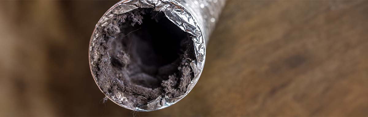 A dirty laundry flexible aluminum dryer vent duct ductwork filled with lint, dust and dirt stock photo