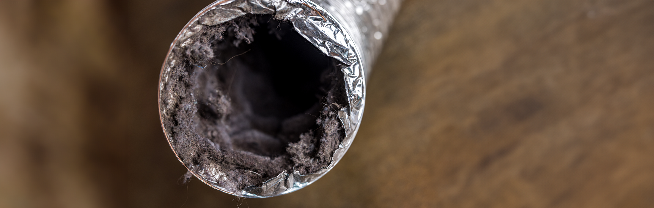 A dirty laundry flexible aluminum dryer vent duct ductwork filled with lint, dust and dirt stock photo