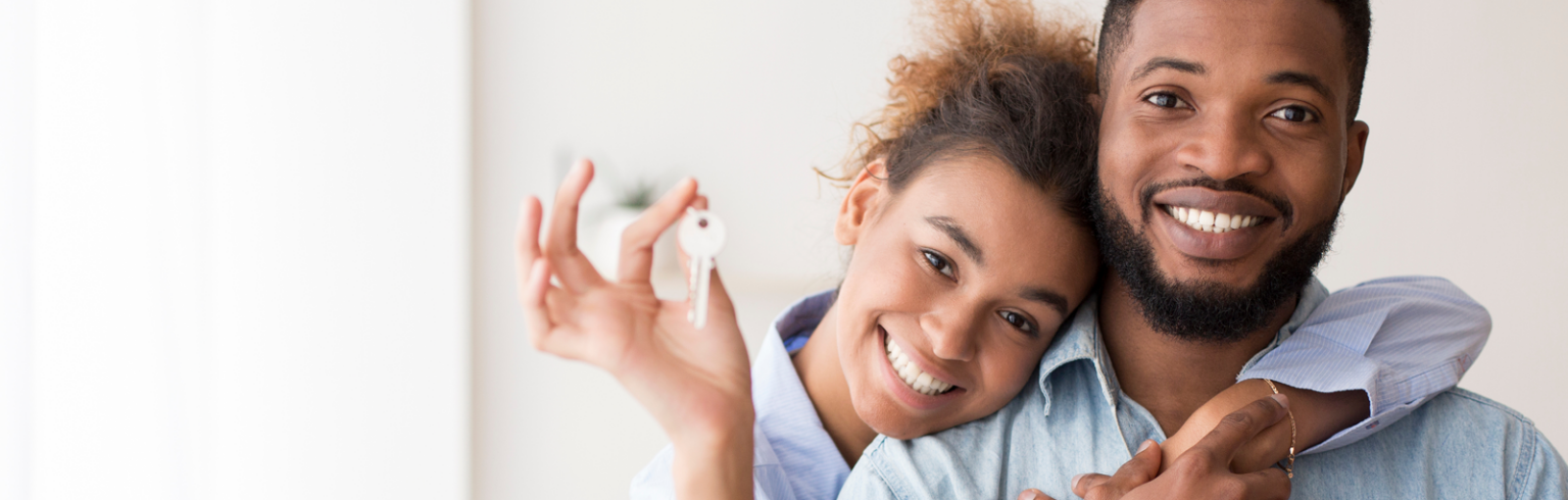 Spouses Showing Key To Camera Embracing In New Home