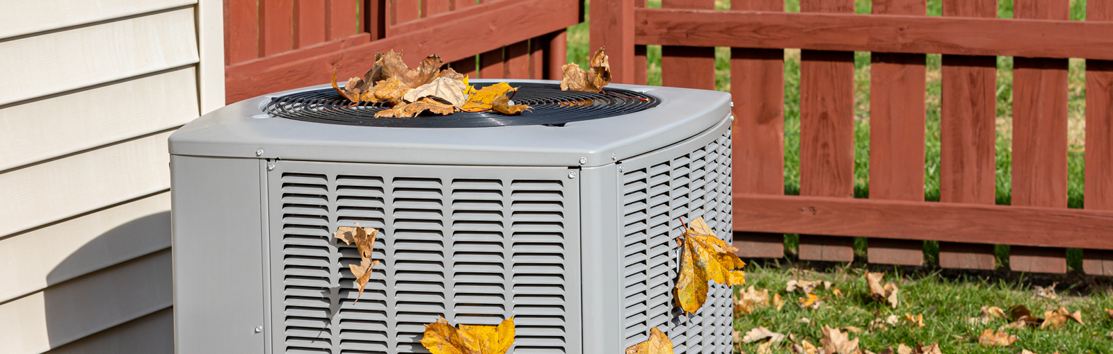 Dirty air conditioning unit covered in leaves during autumn. Home air conditioning, HVAC, repair, service, fall cleaning and maintenance.